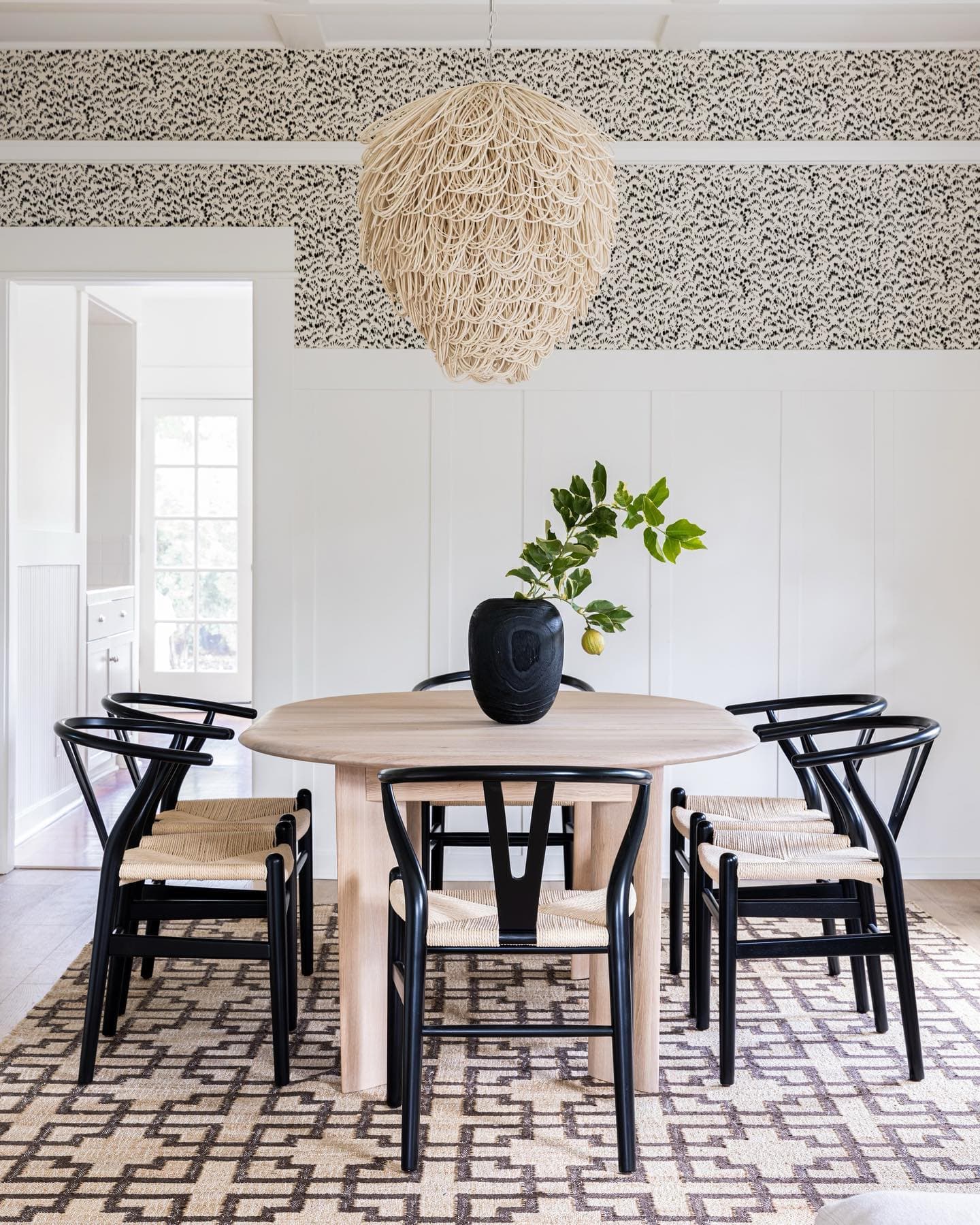 A dining room, finished under a woven pendant.
